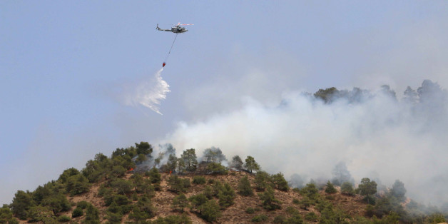 A helicopter drops water on a forest fire in the Cypriot village of Eyrixou in the Troodos mountain area on June 20, 2016.
Aircraft from Britain and Greece have joined Cypriot firefighters in the battle to control some of the worst forest fires to have hit the island in years, officials said. Israel had already sent aircraft to Cyprus when a fire broke out on June 18 at Argaka in the northwestern tourist region of Paphos, fanned by strong winds and scorchingly high temperatures.
/ AFP / SAKIS SAVVIDES (Photo credit should read SAKIS SAVVIDES/AFP/Getty Images)