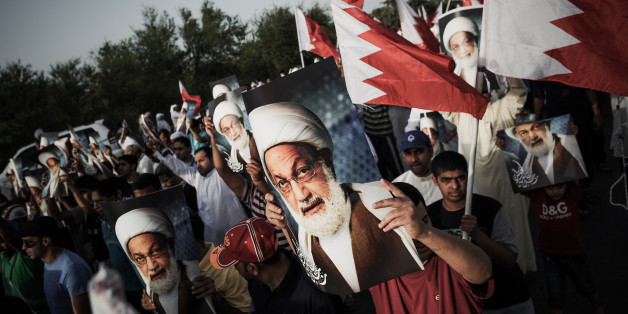Bahraini demonstrators hold pictures of Bahraini senior Shiite cleric Sheikh Issa Qassem during a protest against the regime and to show solidarity with the cleric in the village of Abu Saiba, west of Manama, on May 17, 2013. Bahrain's main opposition accused government troops of raiding the home of the country's leading Shiite cleric, and warned that authorities will bear responsibility for this 'dangerous' act. AFP PHOTO/MOHAMMED AL-SHAIKH (Photo credit should read MOHAMMED AL-SHAIKH/AF