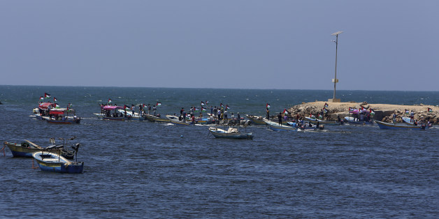 Palestinian protesters sail into the Mediterranean sea while waving their national flags during a protest calling to free the Marianne vessel one of four boats sailing to break the blockade on Gaza strip, at the fishermen port in Gaza City, in the northern Gaza Strip, Monday, June 29, 2015. Israel's navy intercepted a Swedish vessel attempting to breach a naval blockade of Gaza early Monday and was redirecting it to an Israeli port, the military and the activists said. (AP Photo/Adel Hana)