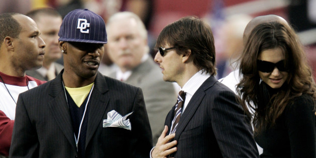 Actors Jamie Foxx (L), Tom Cruise (C) and Katie Holmes talk on the Washington Redskins sidelines before the Monday Night Football game against the Minnesota Vikings in Landover, Maryland September 11, 2006. REUTERS/Gary Cameron (UNITED STATES)