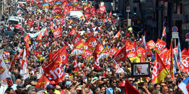 CORRECTS THE DAY. Workers hold flags and demonstrate during a day of strikes and protests, in Marseille, southern France, Tuesday, June 14, 2016. Workers strike across sectors of the French economy and march through French cities in what unions hope is a huge outpouring of discontent at changes to labor protections and a big challenge to the government. (AP Photo/Claude Paris)