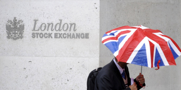 A worker shelters from the rain as he passes the London Stock Exchange in the City of London at lunchtime October 1, 2008. REUTERS/Toby Melville/File Photo