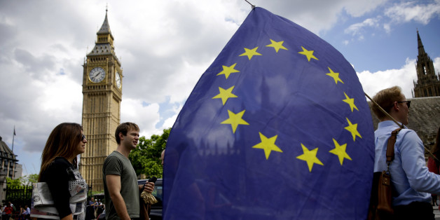 A remain supporter stops to talk to people as he walks around with his European flag across the street from the Houses of Parliament in London, Friday, June 24, 2016. Britain's Prime Minister David Cameron announced Friday that he will quit as Prime Minister following a defeat in the referendum which ended with a vote for Britain to leave the European Union. (AP Photo/Matt Dunham)