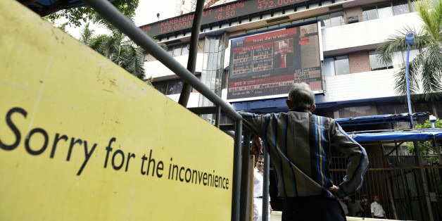 MUMBAI, INDIA - JUNE 25: People look at a screen across a road displaying the Sensex on the facade of the Bombay Stock Exchange building after Britain's exit from the European Union (EU), on June 25, 2016 in Mumbai, India. Britain voted to break away from the European Union on Friday, shattering the unity of a 60-year-old continental bloc, prompting the exit of Prime Minister David Cameron and rattling the world of finance and business. In India, shares fell more than 4% on the news but recovered by half after authorities moved to calm investor worries. The benchmark BSE ended 2.2% down, its biggest single-day percentage fall since February. (Photo by Arijit Sen/Hindustan Times via Getty Images)