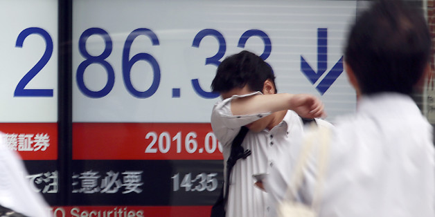 A man stands in front of an electronic stock board showing Japan's Nikkei 225 index at a securities firm in Tokyo, Friday, June 24, 2016. World financial markets were rocked Friday by Britain's vote to leave the European Union, with stock markets and oil prices crashing and the pound hitting its lowest level in three decades. (AP Photo/Eugene Hoshiko)