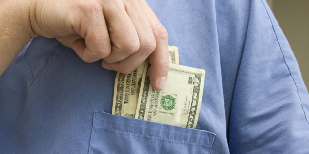 Doctor placing money in his pocket