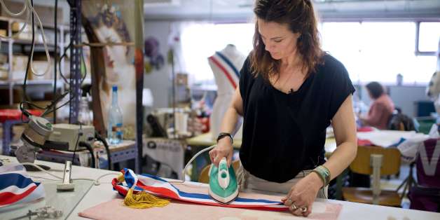 TO GO WITH STORY BY CHRISTIAN GAUVRY
This picture taken on April 2, 2014 at the 'Le Mee Atelier' manufacturing company shows an employee ironing a tricolour mayor sash in Saint-Gregoire, near Rennes, western France. In France, there are five or six companies that manufacture 100 percent made-in-France tricolour sashes for mayors and their deputies, and they are doubling efforts to fulfill demands after the mayoral elections. AFP PHOTO / JEAN-SEBASTIEN EVRARD (Photo credit should read JEAN-SEBASTIEN EVRARD/AFP/Getty Images)