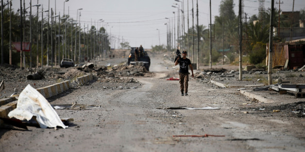 A member of Iraqi counterterrorism forces walks with his weapon in Falluja, Iraq, June 26, 2016. REUTERS/Thaier Al-Sudani