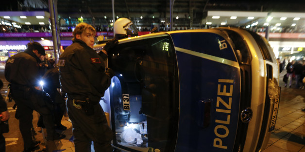 German riot police officers use torches to look for their personal belongings in an overturned police van following a demonstration by German far-right groups in Cologne October 26, 2014. The demonstration against Islamic extremism was organized by neo-Nazi groups and members of Germany's football hooligan scene. REUTERS/Wolfgang Rattay (GERMANY - Tags: CIVIL UNREST POLITICS)