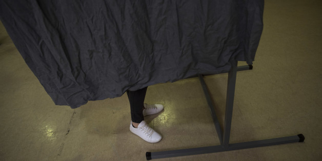 A woman prepares her ballot paper in a booth before casting her vote for the national elections, in Pamplona northern, Spain, Sunday, June 26, 2016. Spaniards are voting in a general election, just six months after a last unsuccessful attempt to pick a new government. (AP Photo/Alvaro Barrientos)