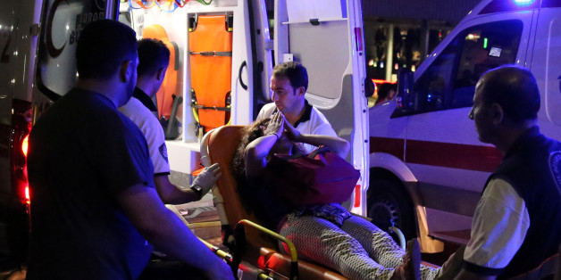 An injured woman covers her face as she is carried by paramedics into ambulance at Istanbul Ataturk airport, Turkey, following a blast June 28, 2016. REUTERS/Goran Tomasevic