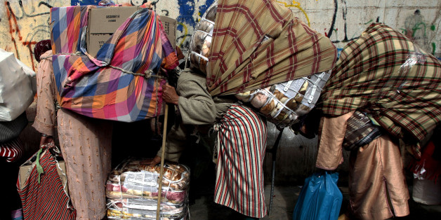 Women are bent double by sacks of goods at the Spain-Morocco border near Spain's North African enclave of Ceuta, in this April 19, 2007 photo. Ceuta officially prides itself on its harmonious mix of cultures, but fears of terrorism are souring relations between Christians and Muslims. To match feature SPAIN-SECURITY/ REUTERS/Anton Meres (SPAIN)