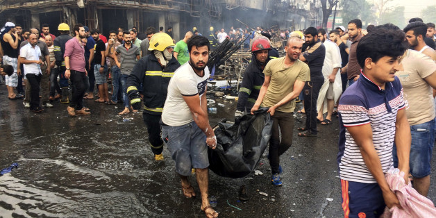Iraqi firefighters and civilians carry bodies of victims killed in a car bomb at a commercial area in Karada neighborhood, Baghdad, Iraq, Sunday, July 3, 2016. Bombs went off early Sunday in two crowded commercial areas in Baghdad. (AP Photo/Khalid Mohammed)