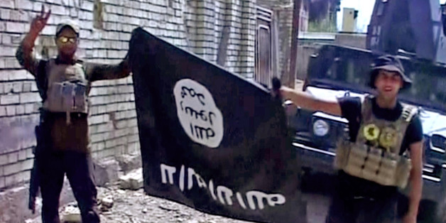 This image made from Associated Press video shows, Iraqi troops turn the Islamic State flag upside down in Fallujah, Iraq, Sunday, June 26, 2016. A senior Iraqi commander declared that the city of Fallujah was "fully liberated" from Islamic State group militants on Sunday, after a more than monthlong military operation. (AP Video via AP)