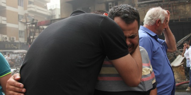 BAGHDAD, IRAQ - JULY 03: Iraqi people who lost their relatives mourn after a suicide car bombing, claimed by the terrorist organization DAESH, in the Karrada neighborhood of Baghdad, Iraq on July 03, 2016. It is reported that 60 people were killed and 100 wounded in the blast. (Photo by Amir Saadi/Anadolu Agency/Getty Images)