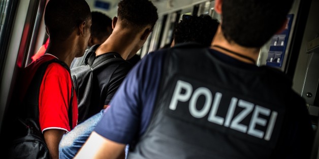 Ein Polizist bei der Kontrolle eingereister Flüchtlinge