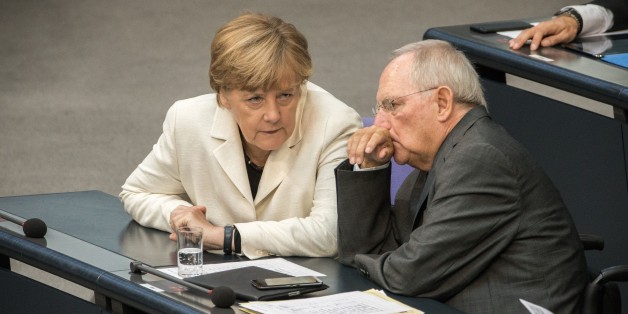 German Finance Minister Wolfgang Schaeuble (R) and German chancellor Angela Merkel attend a parliament session on the opening of a debate on next year's budget at the Bundestag (Lower House of German Parliament) in Berlin, on September 8, 2015. Finance Minister Wolfgang Schaeuble pledged to use Germany's financial firepower at hand to welcome a record influx of refugees, as hundreds more asylum-seekers arrived overnight at the key southern city of Munich. AFP PHOTO / DPA / MICHAEL KAPPELER GERMANY OUT (Photo credit should read MICHAEL KAPPELER/AFP/Getty Images)