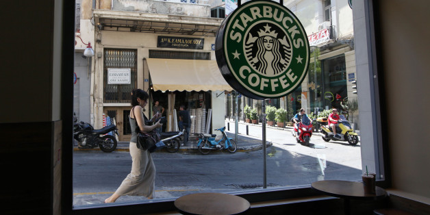 A pedestrian and scooter riders pass the window of a Starbucks Corp. coffee shop in Athens, Greece, on Wednesday, June 20, 2012. All three party leaders have committed to forming a government that will keep Greece in the euro area and fight to change some austerity measures that have led the country into a fifth straight year of recession. Photographer: Chris Ratcliffe/Bloomberg via Getty Images