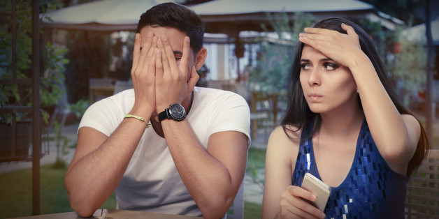 Young adult couple with smart phones upset out on a date