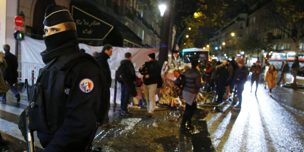 An armed police officer stands guard near the Bataclan concert hall, one of the sites of the shooting attacks as people continue to pay tribute to the victims in Paris, France, November 25, 2015. REUTERS/Eric Gaillard