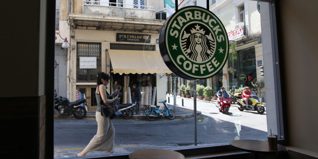 A pedestrian and scooter riders pass the window of a Starbucks Corp. coffee shop in Athens, Greece, on Wednesday, June 20, 2012. All three party leaders have committed to forming a government that will keep Greece in the euro area and fight to change some austerity measures that have led the country into a fifth straight year of recession. Photographer: Chris Ratcliffe/Bloomberg via Getty Images