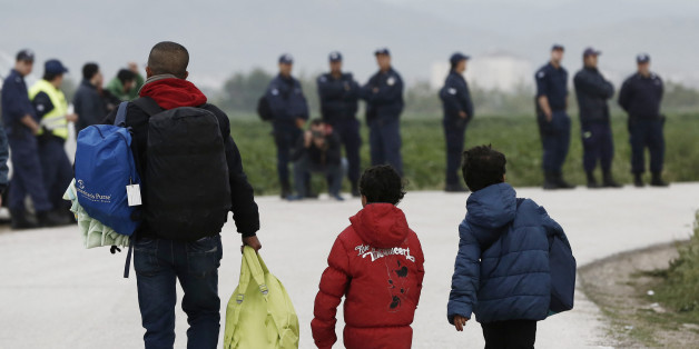 A migrant and children carry their belongings during an evacuation operation by police forces of a makeshift migrant camp at the border at the Greek-Macedonian border near the village of Idomeni, on May 24, 2016. In an operation which began shortly after sunrise on May 24, hundreds of Greek police began evacuating the sprawling camp which is currently home to 8,400 refugees and migrants, among them many families with children, an AFP correspondent said. At its height, there were more than 12,000