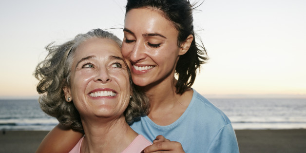 Caucasian mother and daughter hugging at beach