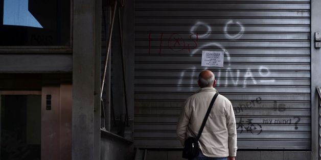 A man reads an announcement while a writing reads 'I m hungry' at a closed urban railway station in Athens, on May 6, 2016, during a 48-hours public transport strike.
Greece's labour unions stage a two-day general strike to protest against controversial government plans to overhaul pensions and increase taxes to meet demands of its bailout creditors. / AFP / LOUISA GOULIAMAKI (Photo credit should read LOUISA GOULIAMAKI/AFP/Getty Images)