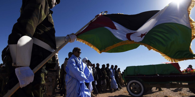 A member of the Sahrawi People's Liberation Army holds a flag of the disputed territory of Western Sahara during the funeral of Polisario Front's secretary general, Mohamed Abdelaziz, on June 4, 2016 in Bir Lahlou, some 220 kilometres (137 miles) southwest of the Algerian town of Tindouf.Abdelaziz, who was in his late 60s, had led the Algeria-backed Polisario since 1976, three years after the group was founded to struggle for independence for the territory, which was annexed by Morocco in 1975.