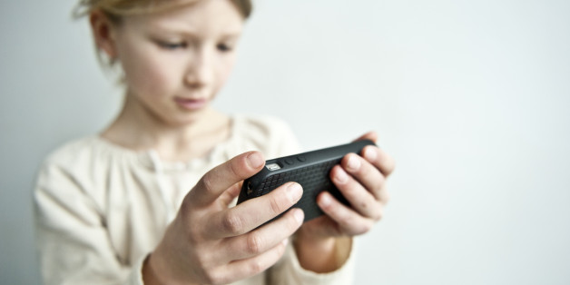 young girl plays with a cell phone