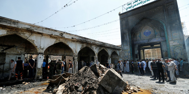 People gather at the site of a suicide attack at the entrance of the Shi'ite Mausoleum of Sayid Mohammed bin Ali al-Hadi in Balad, north of Baghdad, Iraq, July 8, 2016. REUTERS/Thaier Al-Sudani