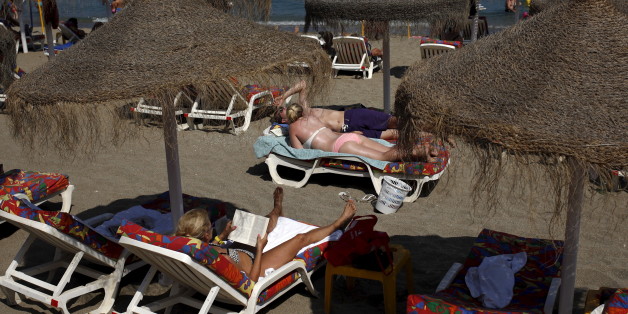 Tourists sunbathe on a beach in Fuengirola, on Costa del Sol, southern Spain, July 12, 2015. The Spanish government raised the terror-alert level to 4, out of a maximum of 5, after the attacks in France, Tunisia and Kuwait, Spain's Interior Minister Jorge Fernandez Diaz announced on June 26. Picture taken July 12, 2015. REUTERS/Jon Nazca