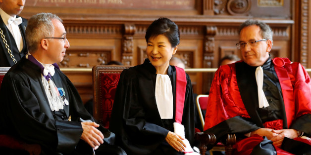 South Korean President Park Geun-hye (C) reacts after she was presented with the insignia of Doctor Honoris Causa by Francois Weil (L), rector of the Academy of Paris and Jean Chambaz (R), President of the Pierre-et-Marie-Curie University, during a ceremony at La Sorbonne university in Paris, France, June 3, 2016. REUTERS/Charles Platiau