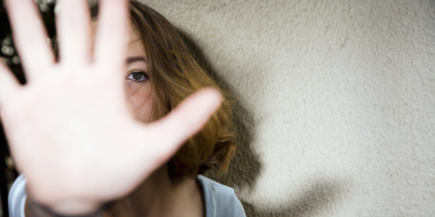 Teenage girl (12-13) holding hand up to block being photographed