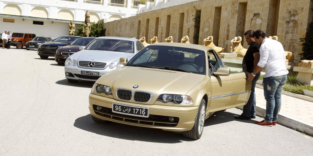 Men look at a car that once belonged to former Tunisian President Zine el-Abidine Ben Ali and his family during a public auction in Tunis May 14, 2014. Cars once owned by Ben Ali, the veteran autocrat brought down in the first Arab Spring uprising in January 2011, have been put up on auction, according to local media. REUTERS/Zoubeir Souissi (TUNISIA - Tags: TRANSPORT POLITICS SOCIETY WEALTH)