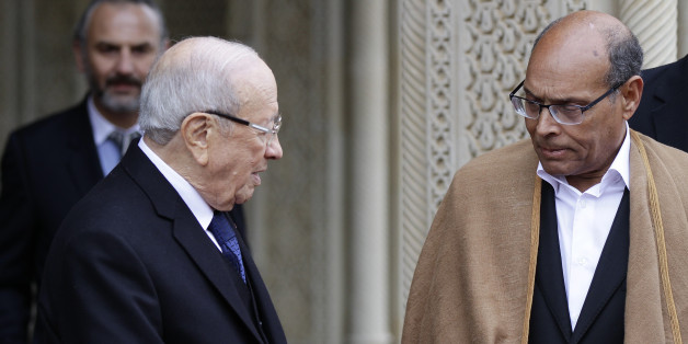 Tunisia's new President Beji Caid Essebsi (L) shakes hands with outgoing interim President Moncef Marzouki as he leaves the Carthage Palace in Tunis December 31, 2014. Veteran politician Essebsi was sworn in as Tunisian president on Wednesday, giving the country a democratically elected leader four years after an uprising ousted autocrat Zine El-Abidine Ben Ali. REUTERS/Anis Mili (TUNISIA - Tags: POLITICS)