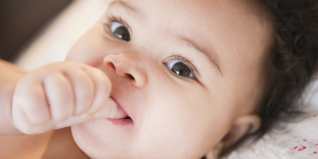 Close up of mixed race baby sucking thumb