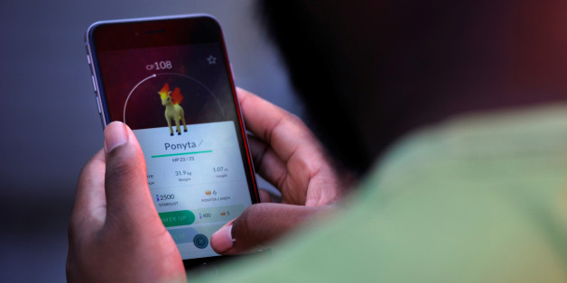 Theodore Belizaire plays the augmented reality mobile game "Pokemon Go" by Nintendo in Times Square, New York City, U.S. July 11, 2016. REUTERS/Mark Kauzlarich