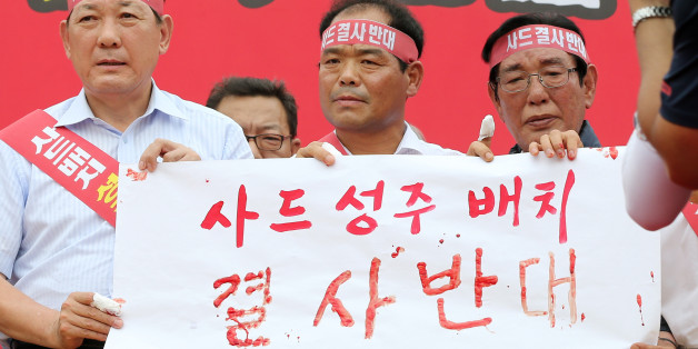 13일 오전 경북 성주군 성주읍 성밖숲에서 열린 사드 배치 반대 군민 궐기대회에서 김항곤 성주군수(왼쪽부터), 배재만 성주군의회의장, 이재복 사드성주배치반대범군민비대위원장이 직접 쓴 혈서를 군민들에게 보여주고 있다.