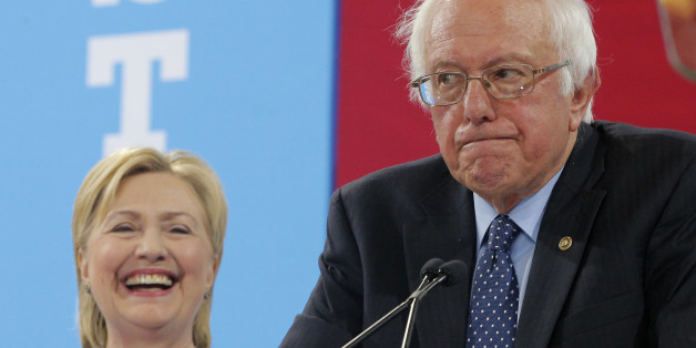 Democratic U.S. presidential candidate Hillary Clinton smiles as Senator Bernie Sanders pauses while endorsing her during a campaign rally in Portsmouth, New Hampshire, U.S., July 12, 2016. REUTERS/Brian Snyder