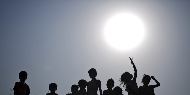 Children with their containers are silhouetted against the sun as they wait to fill drinking water from a water tanker provided by the state-run Delhi Jal (water) Board on a hot summer day in New Delhi, India, May 11, 2015. Temperature in Delhi on Monday reached 42.3 degree Celsius (108.14 degree Fahrenheit), according to India's metrological department website. REUTERS/Anindito Mukherjee