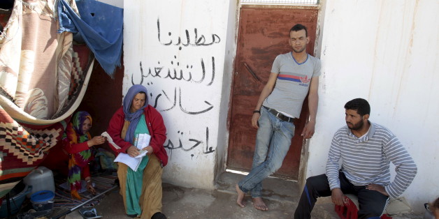 Protesters are seen near tents in Metlaoui, Tunisia May 11, 2015. Few shops are open in the Tunisian town of Metlaoui and the local phosphate mine lies idle, blockaded by unemployed young men demanding the government fulfill the economic promises of their country's revolution. Dozens of protest tents are pitched across the rural town with placards calling for "Dignity" and "Work". REUTERS/Zoubeir Souissi