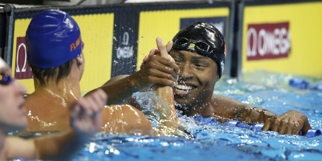 Cullen Jones, right, reacts with Caeleb Dressel, left, after their heat in the men's 50-meter freestyle preliminaries at the U.S. Olympic swimming trials, in Omaha, Neb., Friday, July 1, 2016. (AP Photo/Nati Harnik)