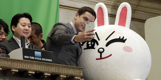 New York Stock Exchange President Tom Farley, center, takes a selfie with Line character Cony on the bell podium at the NYSE, Thursday, July 14, 2016. Line Chief Strategy & Marketing Officer Jun Masuda is at left, before his company's IFO.