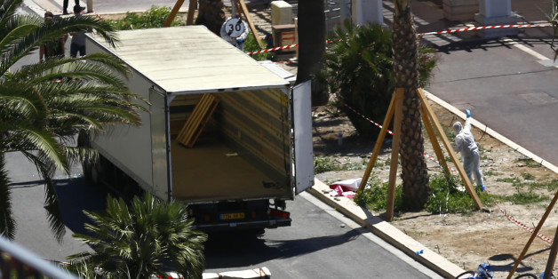 Police officers work near the truck that mowed through revelers in Nice, southern France, Friday, July 15, 2016. A large truck mowed through revelers gathered for Bastille Day fireworks in Nice, killing more than 80 people and sending people fleeing into the sea as it bore down for more than a mile along the Riviera city's famed waterfront promenade. (AP Photo/Francois Mori)