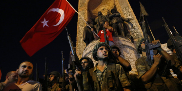 Turkish military stand guard near the the Taksim Square as people wave with Turkish flags in Istanbul, Turkey, July 16, 2016. REUTERS/Murad Sezer
