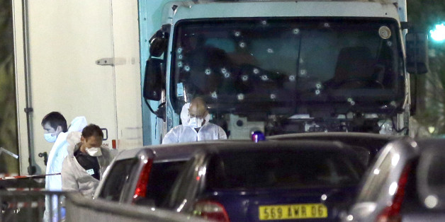 Forensic officers stands near a truck with its windscreen riddled with bullets, that plowed through a crowd of revelers who'd gathered to watch the fireworks in the French resort city of Nice, southern France, Friday, July 15, 2016. At least 80 people were killed before police killed the driver, authorities said. (AP Photo/Claude Paris)