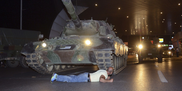 A man lays in front of a tank in the entrance to Istanbul's Ataturk airport, early Saturday, July 16, 2016. Members of Turkey's armed forces said they had taken control of the country, but Turkish officials said the coup attempt had been repelled early Saturday morning in a night of violence, according to state-run media. (Ismail Coskun/IHA via AP)