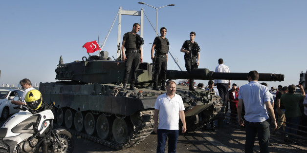 People gather around as Turkish police officers, loyal to the government, stand atop tanks abandoned by Turkish army officers, backdropped by Istanbul's iconic Bosporus Bridge, Saturday, July 16, 2016. Turkish President Recep Tayyip Erdogan declared he was in control of the country early Saturday as government forces fought to squash a coup attempt during a night of explosions, air battles and gunfire that left dozens dead. (AP Photo/Emrah Gurel)