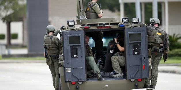 FBI patrol the perimeter of the crime scene in an armored vehicle where Baton Rouge police were shot, in Baton Rouge, La., Sunday, July 17, 2016. Multiple police officers were killed and wounded Sunday morning in a shooting near a gas station in Baton Rouge, less than two weeks after a black man was shot and killed by police here, sparking nightly protests across the city. (AP Photo/Gerald Herbert)
